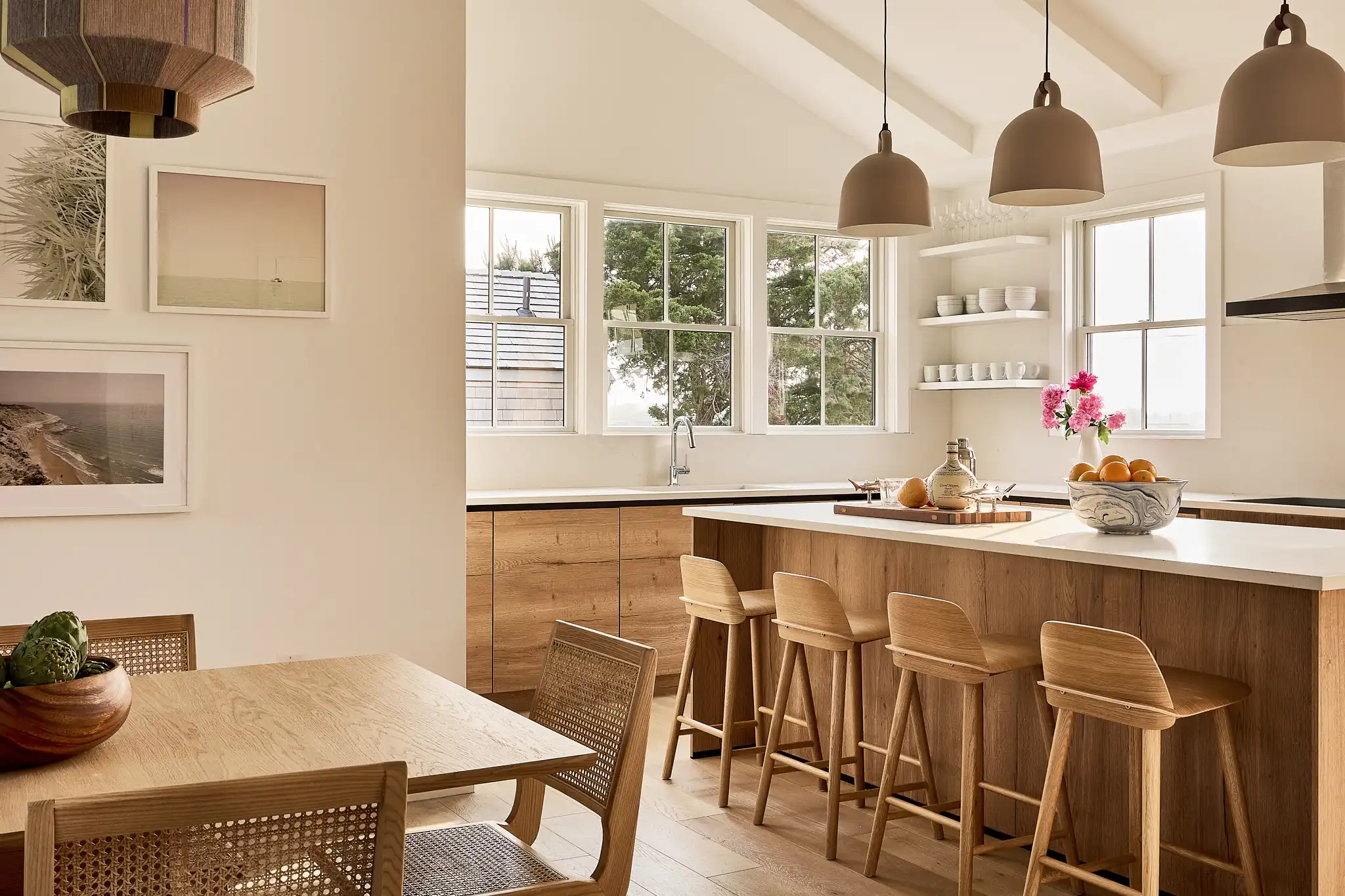 Cozy and inviting kitchen space featuring natural wood cabinetry and a large central island with a white countertop. 